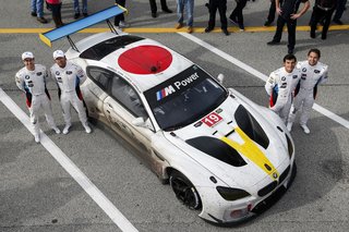 John Baldessari Blazes a Trail at the Daytona International Speedway With BMW Art Car #19 - Photo 11 of 11 - Post-race, drivers Alexander Sims, Bill Auberlen, Bruno Spengler, and Augusto Farfus pose with the muddy—but unscathed—BMW Art Car #19.