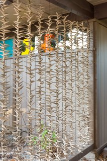 Snag This Midcentury Stunner in Southern California For $799K - Photo 2 of 10 - Strung seashells make up an organic screen for the carport, a natural touch added by the seller.