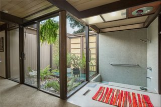 Snag This Midcentury Stunner in Southern California For $799K - Photo 10 of 10 - The sunken tile tub and shower in the ensuite master bathroom enjoys an outdoor connection in the form of a small atrium.