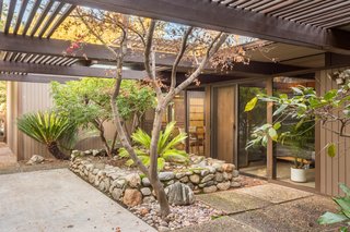 Snag This Midcentury Stunner in Southern California For $799K - Photo 8 of 10 - The dining room and bedrooms lead to a large garden patio.