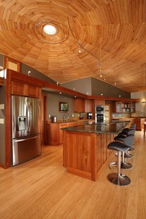 Empowered to act as his own general contractor with Deltec Homes' support, Sanders cut wood from his own property for the ceiling, trim, and cabinetry—drying, forming, and finishing the material on site.