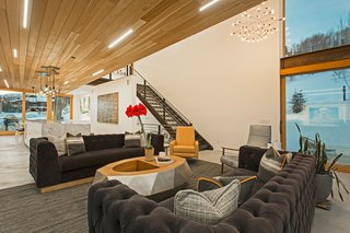 Mullin discovered the Cirrus Linear LED lights in the red cedar wood ceiling at Dwell on Design in Los Angeles in 2015. Cold-rolled steel stairs lead to the upper level and add a touch of industrialism to the space. Adjacent to the living room is a large outdoor balcony, accessible through disappearing sliding glass doors.