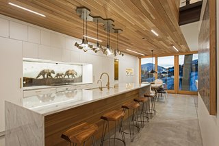 A chandelier by artist Joe Norman provides a dramatic accent to the kitchen and dining areas. The backsplash was a commission by the artist KOLABS, part of Mullin's wife's gallery.