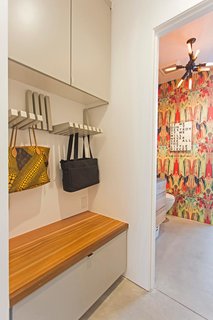 A clever storage area holds purses and bags, while a bench hides away bulkier items.