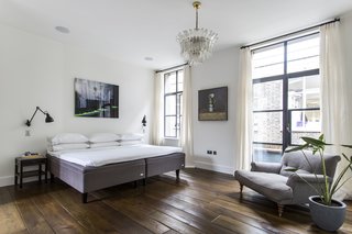 Stay in a Converted Victorian Cooperage in London - Photo 7 of 7 - Four bedrooms on the upper level feature wood floors, modern art, and ceiling beams, while the master bedroom on the third floor (pictured here) enjoys an ensuite bathroom and private terrace. On the rooftop, another bronze-clad terrace supplies a barbecue and city views.