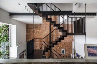 Stay in a Converted Victorian Cooperage in London - Photo 1 of 7 - Entering the apartment from the street level, guests meet a dramatic, three-story atrium and a feature staircase. A glass balustrade heightens the effect.