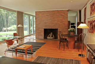With $1 Million, You Can Save Philip Johnson’s First Commissioned House - Photo 3 of 9 - Reminiscent of the Glass House, a monumental brick fireplace stands in the center of the living room. "Because the home was designed for a couple without children, it's a very large, open space that was signature of the modern experiments at the time," says Matthew. 