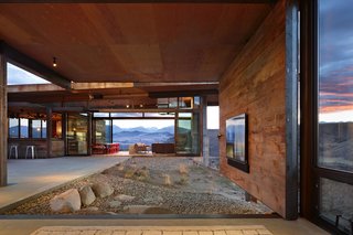 A Steel-and-Glass Compound Is One Family’s Launchpad For Adventure - Photo 7 of 10 - A television is mounted on a pivoting wall that can either face the indoors or out toward the courtyard, emphasizing the entertainment aspect of the home.