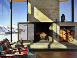 A Steel-and-Glass Compound Is One Family’s Launchpad For Adventure - Photo 3 of 10 - A sliding mesh screen glides over the fireplace, which features a built-in cubby for a stockpile of wood.