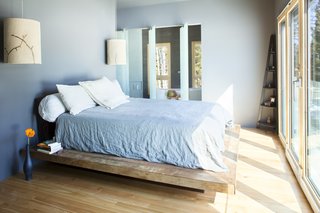 The master bedroom, which looks out through a wall of glass at the Whitefish Range, benefits from solar tubes that let in additional light. Center-mounted glass panels pivot to let you into the master bath.