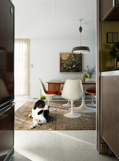 A Rare Midcentury Prefab Looks Just Like it Did in 1958—Down to the Knoll and Paul McCobb Interiors - Photo 7 of 13 - The homeowners love to host guests in the dining room, which features another set of Saarinen furniture. Banksy, a rescue lab and setter mix, takes a break from chasing toys up and down the hallways.
