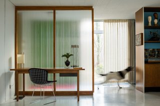A Rare Midcentury Prefab Looks Just Like it Did in 1958—Down to the Knoll and Paul McCobb Interiors - Photo 2 of 13 - A Paul McCobb reeded glass panel provides a contemplative backdrop for a walnut Knoll writing desk and Bertoia Side Chair. "They feel like the soul of the house," says Coscarelli of the partitions. "They change constantly with the light." A Noguchi Number 9 Lamp is one of several original to the house.