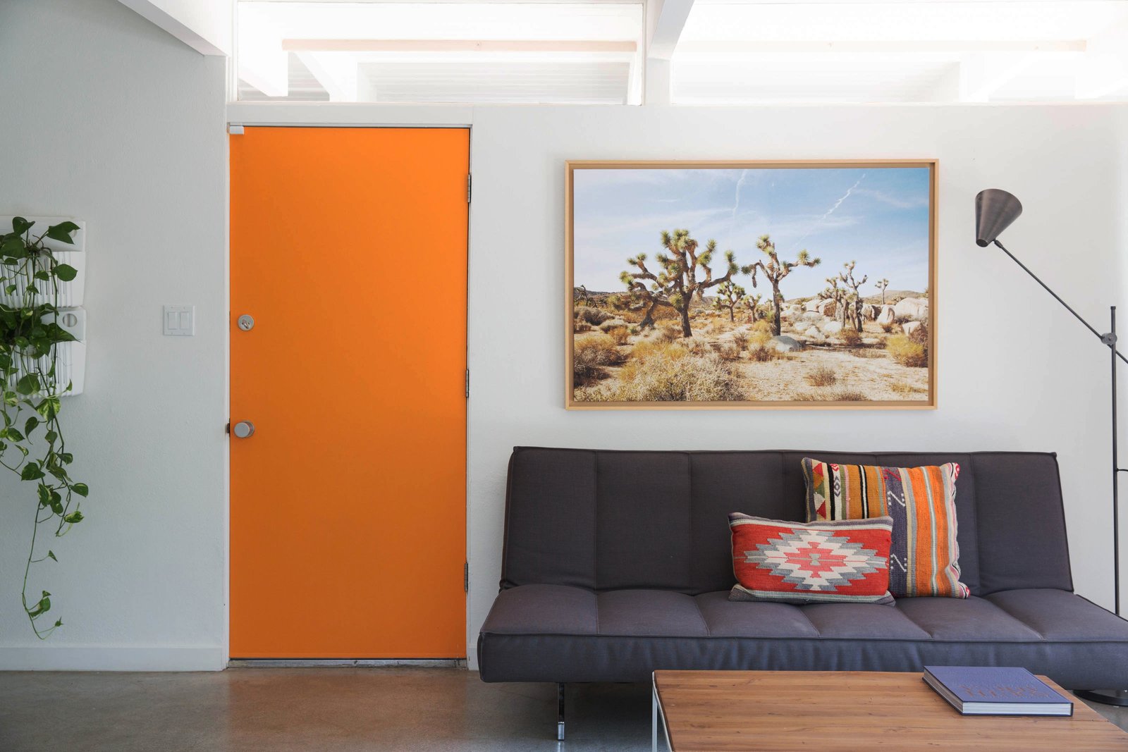 The wood-and-brick structure, painted white with a cheery orange doors, embodies quintessential Palm Springs architecture with a fresh, contemporary twist. Tongue-and-groove ceilings with exposed beams, an original fireplace, and clerestory windows round out the midcentury charm. Buyers can choose to purchase the furnishings as well, which are minimalist with Southwestern-inspired textures.