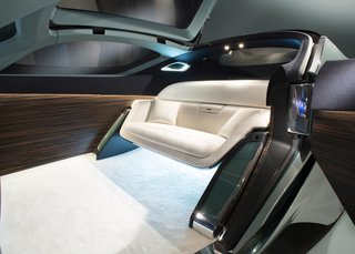 The Rolls-Royce 103EX Envisions the Brand's Next 100 Years - Photo 8 of 9 - Interior details include an expansive OLED touch-screen, Macassar wood paneling, deep-pile ivory wool carpet, and a silky wool sofa. A luggage compartment is hidden near the front wheels.