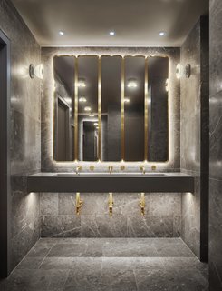 Porcelain tile, marble countertops, and brass trimmings give the in-room bathrooms a luxe feel.