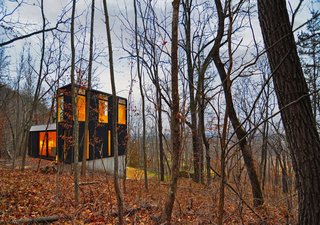 10 Modern Wintry Cabins We’d Be Happy to Hole Up In - Photo 3 of 10 - Johnsen Schmaling Architects designed the modest Stacked Cabin in a remote Wisconsin forest. Working with a tight budget, they kept the structure simple and minimized the footprint by going vertical and carving into the sloped site.