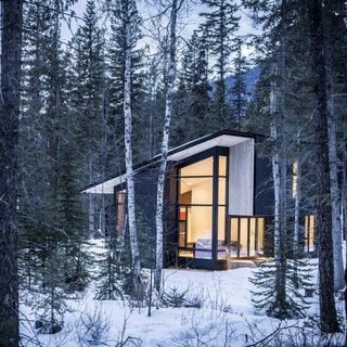 10 Modern Wintry Cabins We’d Be Happy to Hole Up In - Photo 7 of 10 - Form & Forest have designed the ultimate modern cabin that you can actually rent! Surrounded by wilderness, the retreat sits on the Blaeberry River near Golden, British Columbia with vaulted ceilings in the living room that afford incredible views of the forest, mountains, and river.