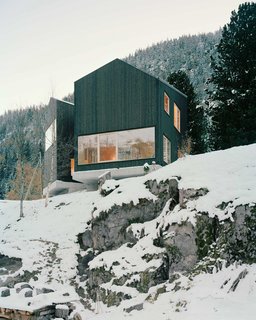 10 Modern Wintry Cabins We’d Be Happy to Hole Up In - Photo 10 of 10 - Lacroix Chessex Architectes realized La Maison aux Jeurs, a cabin in Les Jeurs, Switzerland situated on a rocky hill above the road. The structure is divided into two volumes that are angled 45 degrees apart with a connection on the mountain side. Both volumes are designed with different views of the valley below.