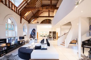 Traditional Churches Become Modern Homes - Photo 1 of 10 - A Victorian-style church in London was converted by Gianna Camilotti Interiors into a modern home while keeping its historic charm. The outside may remain a traditional red brick, but the interior features white walls and floors, along with arched windows and wooden beams.
