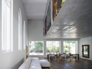 Traditional Churches Become Modern Homes - Photo 10 of 10 - Located in Bern, Switzerland, the 1924 Luke Chapel went from rundown to two new modern homes by Morscher Architekten. To prevent covering the large church windows and to avoid adding support posts, the top apartment is suspended within a concrete box above. The box’s facade was the perfect place to display artwork.