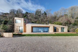 The home’s design began with a traditional cabin form that broke off from there to split, twist, and rotate into four pods. The residence perfectly blends with the surrounding landscape with its larch lad exterior.