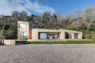 The smallest pod houses the entryway which leads to the main living pod. There, you’ll find the open living space with the kitchen, dining, and living room that face out to the coastal views via the sliding glass doors.