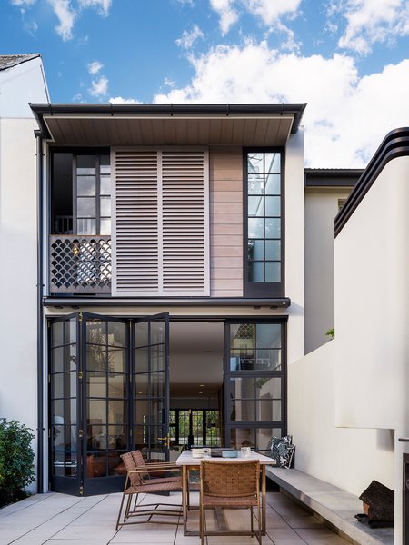 From the internal courtyard the façade architecture is a practical placement of timber windows and shutters. The small scale elements, such as the shutter blades, the fish scale balustrade and the small window panes are intentionally placed to provide a fine texture of materials and patterns to break up the large scale and give a feeling of security.
© Justin Alexander
Photo 5 of Bougainvillea Row House modern home