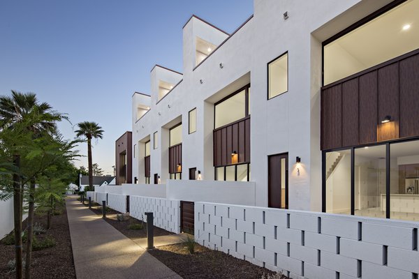 Each unit in this development is accessed by a pedestrian walkway through a private courtyard. The low, spaced concrete block wall provides a social component to the development #infill #development #townhouse #phoenix #modern #urban #wall Photo 2 of Uptown Row modern home