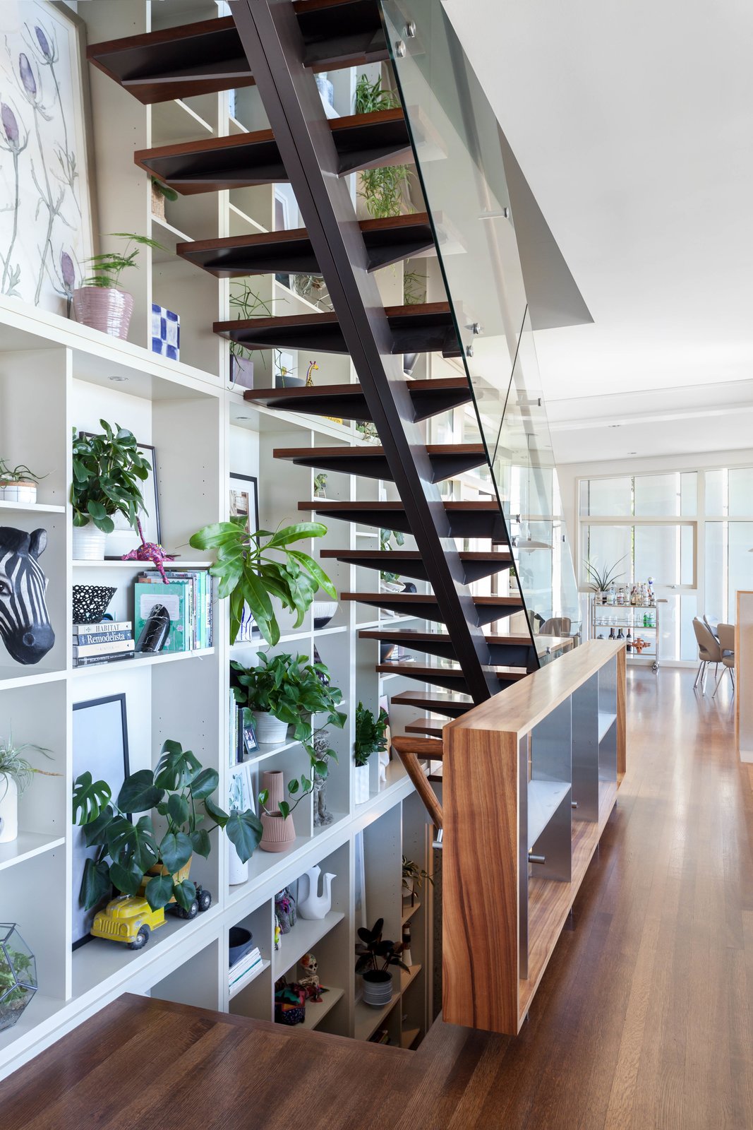 The stair up and down next to the 3 story book shelf