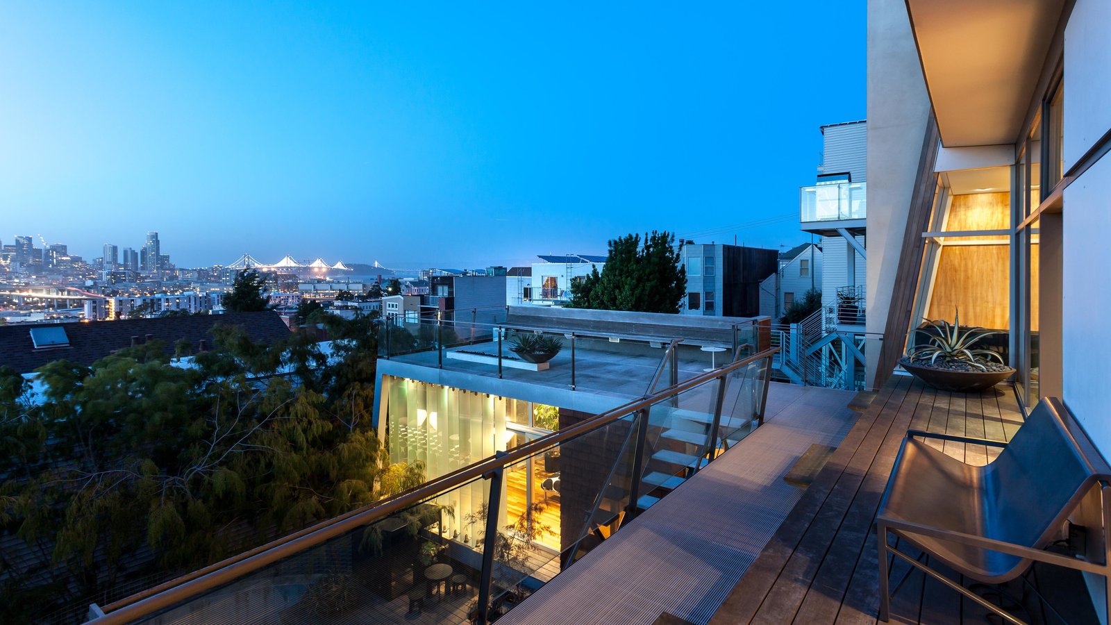 The evening view of the glass louvered studio below with the roof deck.