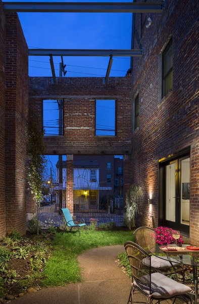 The existing corner row house was, by far, in the worst condition, with collapsed floors and roof structure. The largest problem of the existing structures was turned into one of the greatest assets by transforming the corner building into an exterior semi-private garden space. What once had been a corner storefront has now been re-imagined into a quiet garden with custom steel railings and fence to allow for security yet transparency into the green space. Photo 5 of 48th Street Row modern home