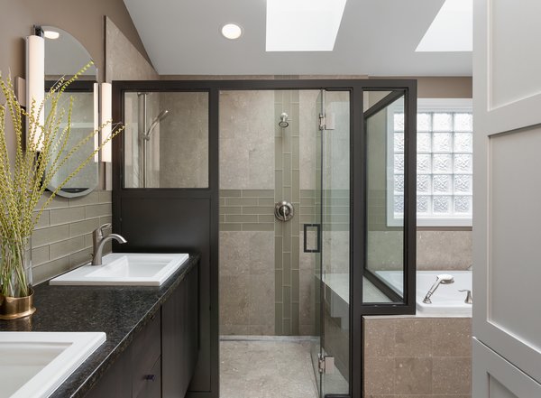 Adding space at this wing of the home allowed for inclusion of this curb-free shower, tub area and generous walk-in closet in the master bathroom, a new laundry room, and a second bathroom for family and guests. Originally, there was only one bathroom in this part of the home that all bedrooms shared. Photo 7 of The Ping Pong Home modern home