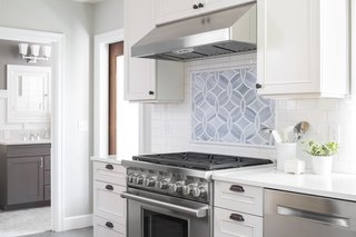 Boeing Castle in Seattle's Blue Ridge Neighborhood Taken to New Heights - Photo 2 of 4 - A custom backsplash was designed using Ann Sacks tile which compliments the marble countertop and accentuates the Wolf range.