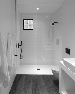 The minimalistic bathroom at the center of the studio separates the sleeping area from the living area .