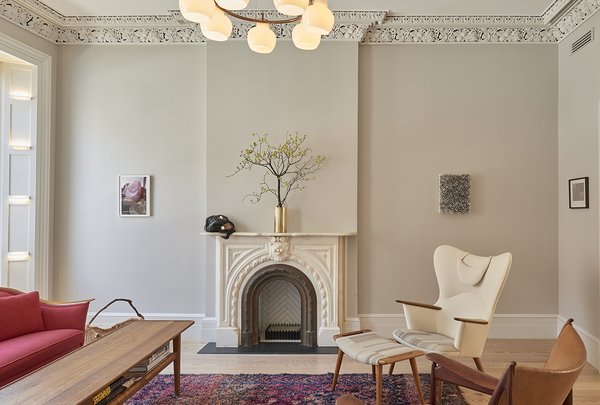 Parlor: A Vilhelm Lauritzen hangs above a Vintage Moroccan rug from Breuckelen Berber. A Finn Juhl Chieftain Chair alongside a Mama Bear Chair; reupholstered and paired with a matching ottoman in Hella Jongerius fabric sit next to a Hans Wegner coffee table.
Ceiling decoration is original – parts of it replicated by Absolute Plastering in Brooklyn. Photo 6 of Carroll Gardens Passive House modern home
