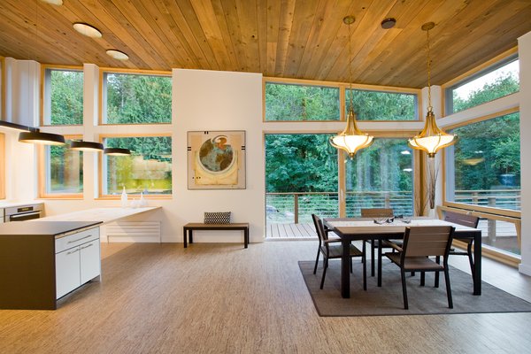 Modern home with windows, casement window type, and wood. Floor-to-ceiling Zola windows in the main living area, gives an expansive view of the surrounding Northwest forest. The tops of these windows reveal the interior cedar clad and the up-swept soffits on the home’s exterior, creating a floating ceiling effect. Slatted spruce wood fly-overs break up the vertical areas of the great room and define separate areas that would otherwise feel like an overwhelmingly expansive space. Photo of Cedar Haus