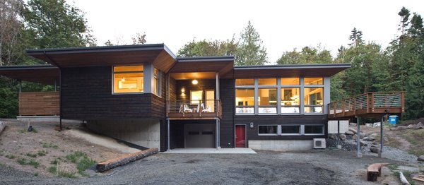 Nestled in a wooded area in the Pacific Northwest, the 1800 sf Passive Cedar Haus was built as a retirement home. The Artisans Group designed the layout of the home, mindful of aging in place, and working to ensure that the home blended in with the surrounding natural beauty. The project meets a complex program, with an unheated sleeping porch for a master bedroom, a screened porch, a 600 sf caretakers apartment/mother in law unit, large wood shop, plus a two car carport. Photo 4 of Cedar Haus modern home