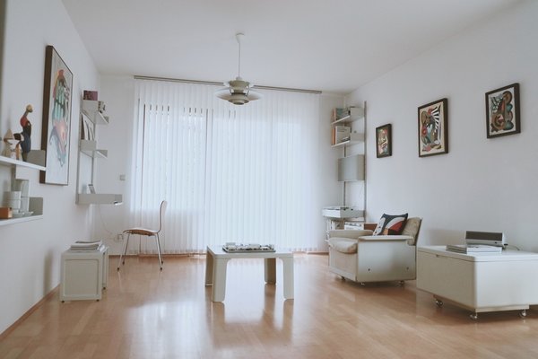 The living room has a white scheme and almost fully furnished with Dieter Rams Vitsoe 606 and 620, 621, including multiple vintage items which are not in production anymore. It also features multiple great pictures from Brazilian/American artist Amauri Torezan and also includes multiple Braun radios and players, with 1962 Braun Audio 1 / L 46 systems integrated into Vitsoe shelving system. Arne Jacobsen 3107 chairs used for mini-workplace and dining. Most of the lighting in the apartment is Poul Henningsen PH5 and PH4/3 from Louis Poulsen. Photo of Philipp's Appartment modern home
