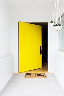 What's the Best Color to Paint Your Front Door? Your Guide to Finding The One - Photo 1 of 22 - This vibrant, happy shade of yellow invites the sunshine (and sunny vibes) in. That's what makes yellow one of my favorite colors. Accessorized with a simple welcome mat and a few hanging plants, this bright door only requires minimal décor to make a big opening statement. 