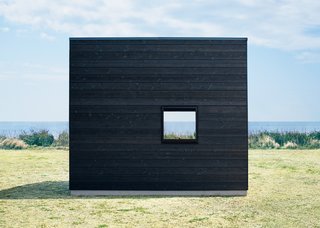 Seeing the hut set against a vast seascape shows how the design allows the structure to be enveloped by the surrounding landscape.