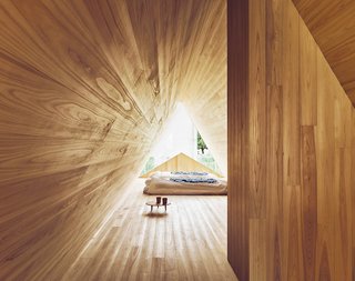 The Community-Run Cedar House by Airbnb and Go Hasegawa Welcomes Guests in Rural Japan - Photo 10 of 12 - The bedroom space is backlit by a unique "A" shape that provides ample natural light—reflecting the cedar's warm, patterned tones.