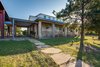 The barn, which is located towards the back of the estate, features multiple large stalls, a warm and inviting finish-out of stained wood and natural stone, and a guest quarters above with 1 bedroom, 1 bathroom, and a full kitchen and living area. The covered riding arena is located just off the barn and has a speaker and lighting system for those evening rides. Photo 13 of The Amber modern home
