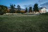 The barn, which is located towards the back of the estate, features multiple large stalls, a warm and inviting finish-out of stained wood and natural stone, and a guest quarters above with 1 bedroom, 1 bathroom, and a full kitchen and living area. The covered riding arena is located just off the barn and has a speaker and lighting system for those evening rides. Photo 10 of The Amber modern home