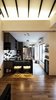 At the heart of the home is the kitchen area - an open concept - with contrasting black and white textured subway tiles for its backsplash against the deep blackness of the countertop. Colours are added with strategic placements of cookbooks, baking books, favourite novels and crockery. The bar stools at the island were both customised and made in Indonesia, their seats beautifully contoured and their legs in a classic shade of gold. Photo 13 of The Singapore Designer Loft: A Fusion of Old and New modern home