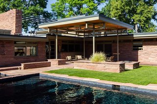 What Would Victor Do? - Photo 2 of 11 - The swimming pool did not originate with the house, but<br>came about later in a 1980 design by Hans Kahn Associates,<br>Inc. The metalwork supporting the patio cover borrows<br>rhythm and form from nearby transom windows. In the<br>Hornbein-era backyard, grass and a swing set prevail, both<br>in the shadow of the second-story solarium.