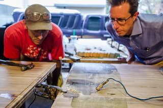 Game On - Photo 2 of 5 - Designer James Davis had been experimenting with electrical erosion for about six months before meeting Vertical Arts' Brian Patty at a networking event. They quickly devised a plan to incorporate the technique into a multi-purpose table for VA's new office space. Using a solution of baking soda and saltwater to provide a general pattern, electrical clamps run through a series of microwave transformers to create a unique design on walnut butcher block. 
