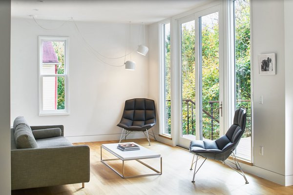 The back of the house serves as the greatest departure from the otherwise preserved proportions of the original Victorian farmhouse. With the thoughtful insertion of a “glass dining cube” and a rehabilitated deck space with sliding doors that can stand open, an outdoor living space creates additional programmatic flexibility while reinforcing the indoor/outdoor connection. Photo 7 of Modern Victorian modern home