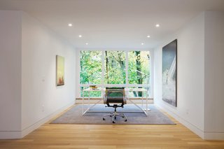 Beyond The Red Door - Photo 8 of 16 - Situated on a sloped-site, each renovated space provides a unique perspective and vista to the dramatic natural surroundings. The office, with its stark modern furnishings and subtle artwork, allows the large window to serve as perhaps the most dramatic, singular frame to the foliage beyond. 