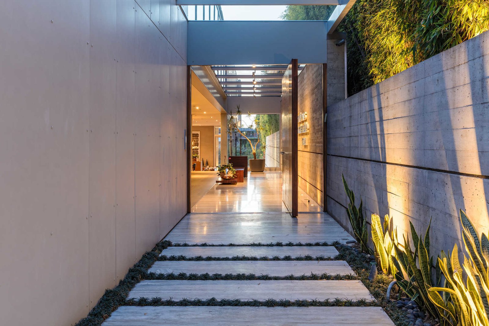A tranquil meditation garden leads to a light-filled entrance gallery punctuated by a glass-paneled ceiling.