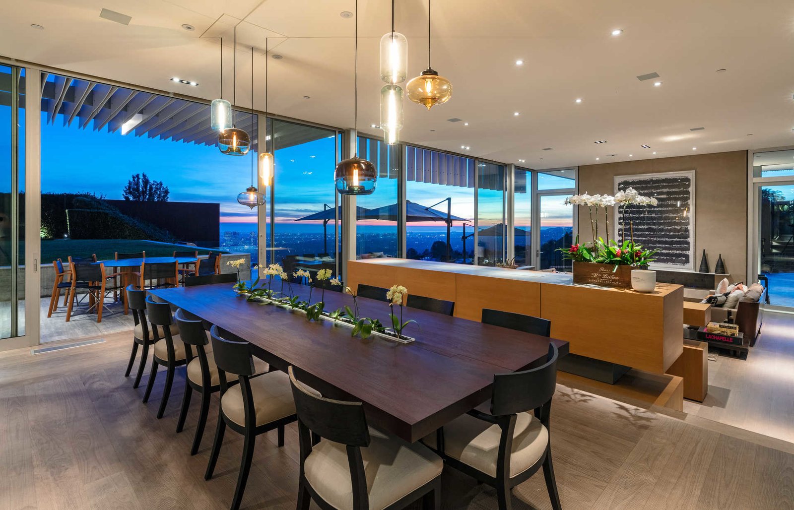 The home’s sliding glass walls blend organically into expansive grounds.